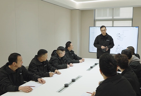 Dayuan technical team receiving product training with mechanical drawings in a meeting room