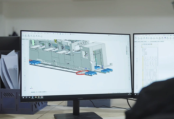 Engineer designing die-cutting machine with 3D CAD software on dual monitors