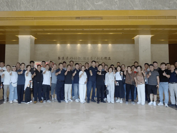 Group photo of printing industry delegation at factory