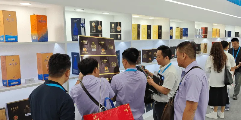 Customers viewing liquor packaging samples at Dayuan Machinery exhibition booth