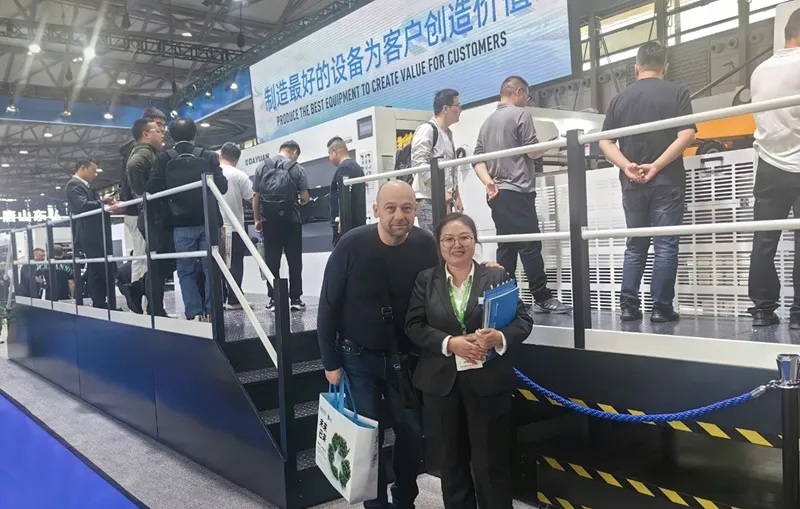 Dayuan Machinery sales rep with international customer at packaging exhibition booth
