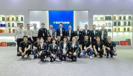 /Dayuan Machinery team photo at exhibition booth with packaging samples