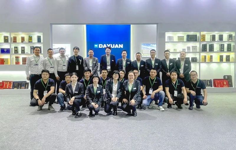 Dayuan Machinery team photo at exhibition booth with packaging samples
