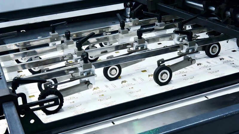 Industrial printing machine feeding printed paper with roller fixtures